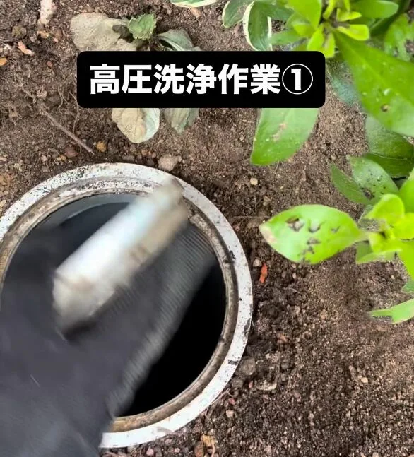枡にノズルを挿入して洗浄している様子